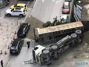 市区一建筑工地运沙车侧翻,轿车车头被压扁